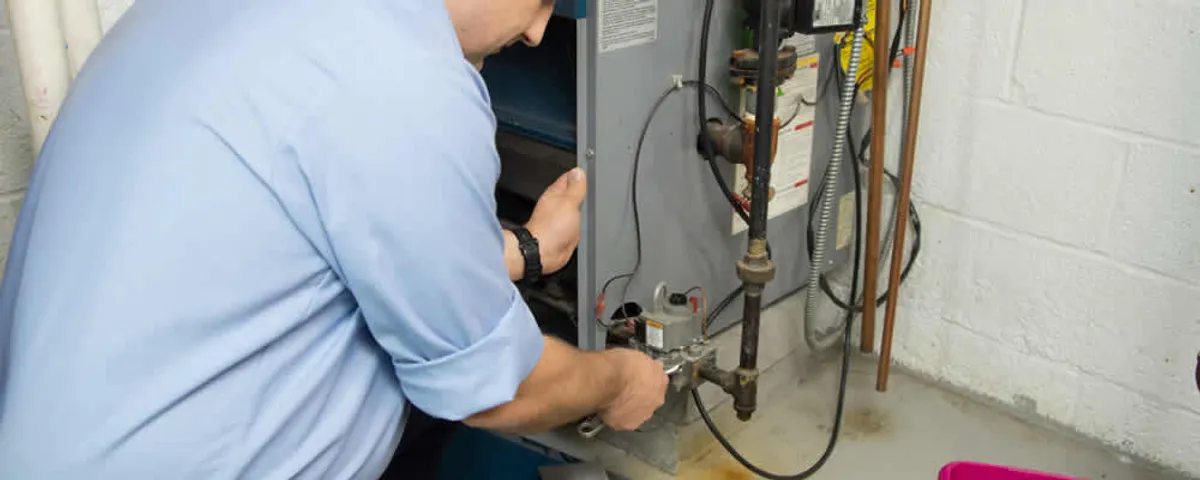 Furnace repair technician inspecting and servicing a home heating system in Mansfield, MA