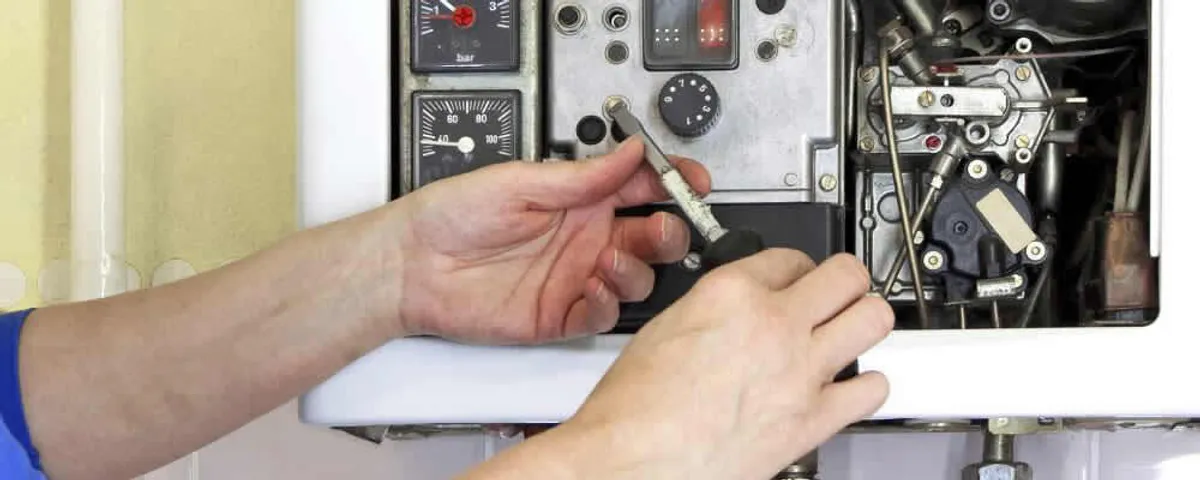 Heating repair technician adjusting boiler controls and components in Mansfield, MA
