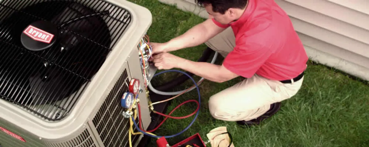 HVAC technician servicing an outdoor air conditioner unit in Mansfield, MA