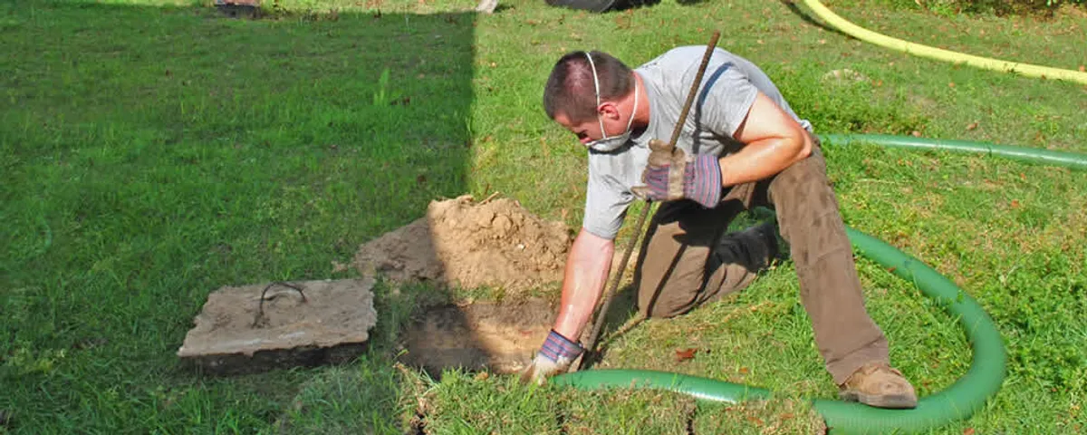 Septic pumping technician servicing a residential septic tank in Mansfield, MA