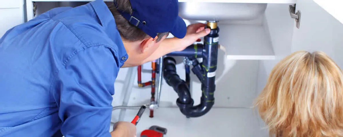 Plumber repairing under-sink drain pipes and fittings in Mansfield, MA